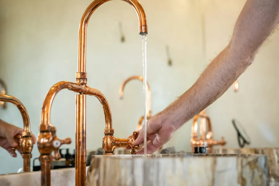 Neu montierte Kupferarmatur an einem Waschbecken